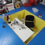 Curiosa � la posizione della postazione di Luigi, che si trova a un livello pi� basso delle macchine da cucire, piazzate alla stessa altezza del pavimento: quest'ultimo funge infatti da piattaforma per le vele e garantisce una cucitura perfettamente lineare